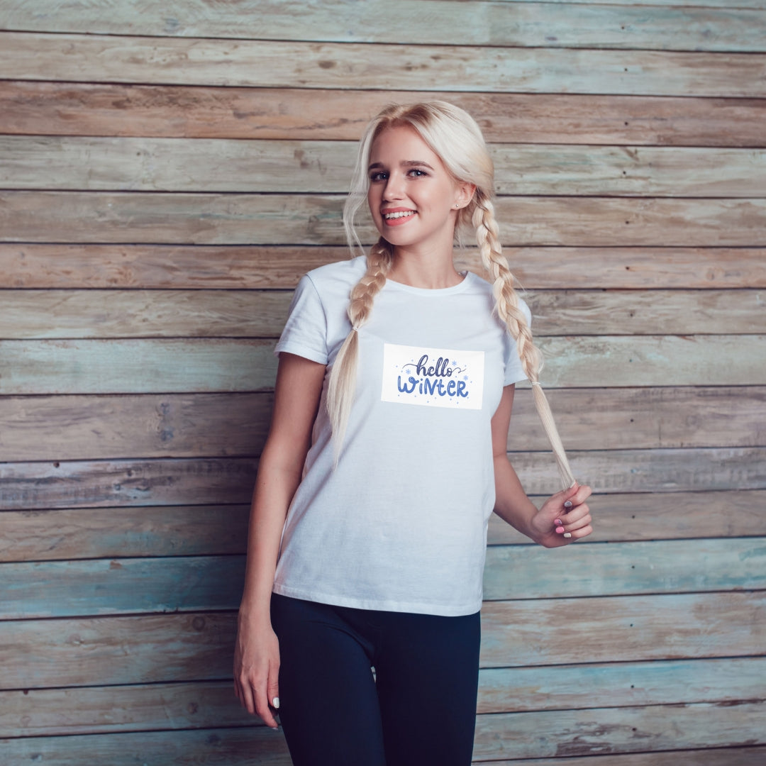 Tricou Kiskedves Hello Winter cu textul albastru scris de mână hello winter și fulgi mici, pe tricou alb.