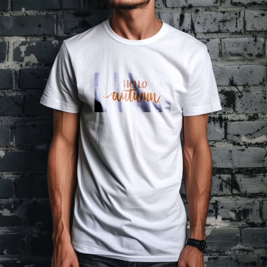 Tricou Kiskedves Hello Autumn cu textul portocaliu scris de mână Hello autumn și puncte mici, pe tricou alb, pe fundal de cărămidă.