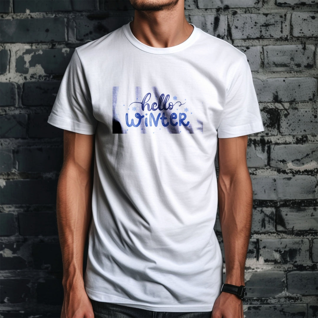 Tricou Kiskedves Hello Winter cu textul albastru scris de mână hello winter și fulgi mici, pe tricou alb, pe fundal de cărămidă.