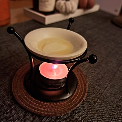 Lampa aromaterapie Kiskedves cu pastila de ceai aprinsă, în lumina serii.