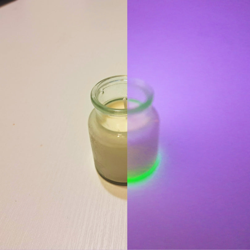 Lumânare magică Kiskedves în sticluță, în imagine împărțită la lumina zilei și în lumină UV violetă, cu baza strălucind verde