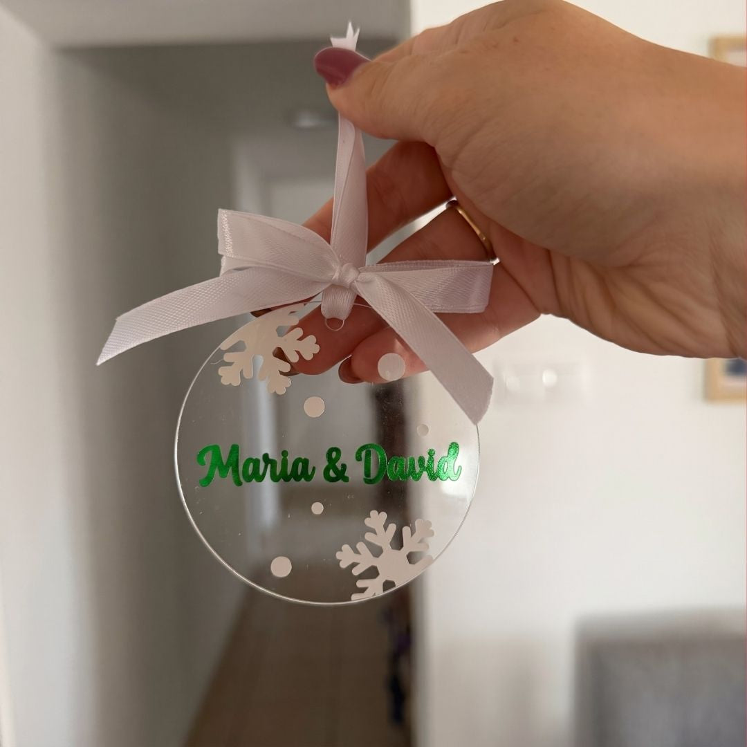 Ornament acrilic ținut în mână, cu text verde și fulgi de nea