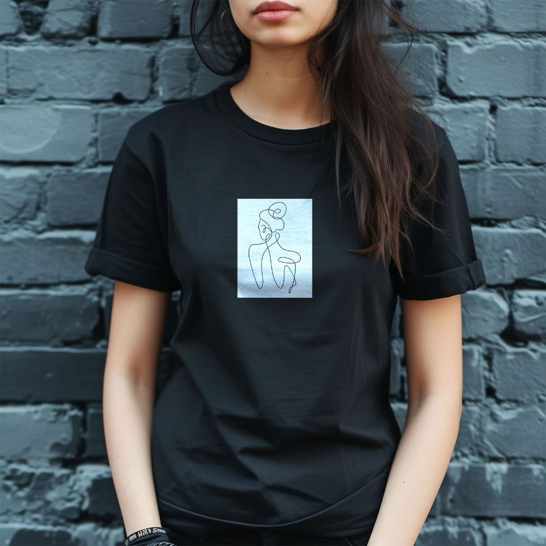 Tricou negru Kiskedves Line Art cu siluetă din spate, pe o modelă brunetă, în fața unui zid de cărămidă.