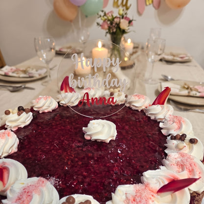 Topper personalizat din acril cu textul „Happy birthday Anna” pe un tort cu zmeură, la o masă festivă