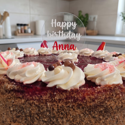 Topper din acril cu textul „Happy birthday Anna” pe un tort cu frișcă
