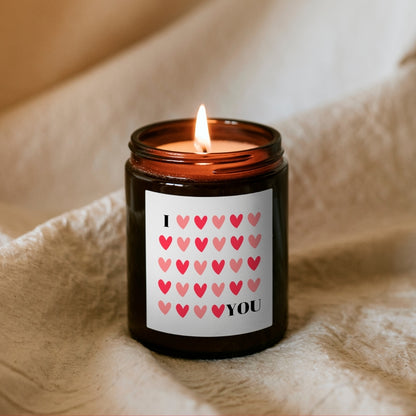 Lumânare Kiskedves I ❤️ YOU aprinsă, din ceară de soia, în borcan maro, cu etichetă cu inimioare roșii și roz.