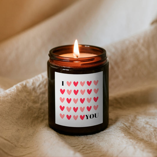 Lumânare Kiskedves I ❤️ YOU aprinsă, din ceară de soia, în borcan maro, cu etichetă cu inimioare roșii și roz.
