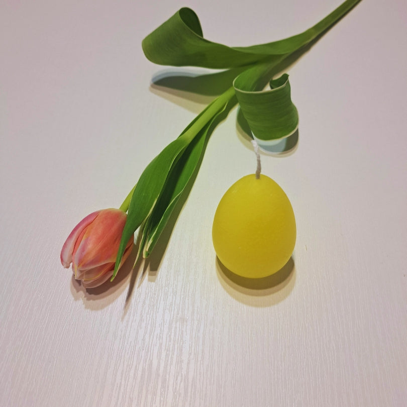 Lumânare ou galbenă de la Kiskedves, alături o lalea culcată și o frunză verde răsucită.