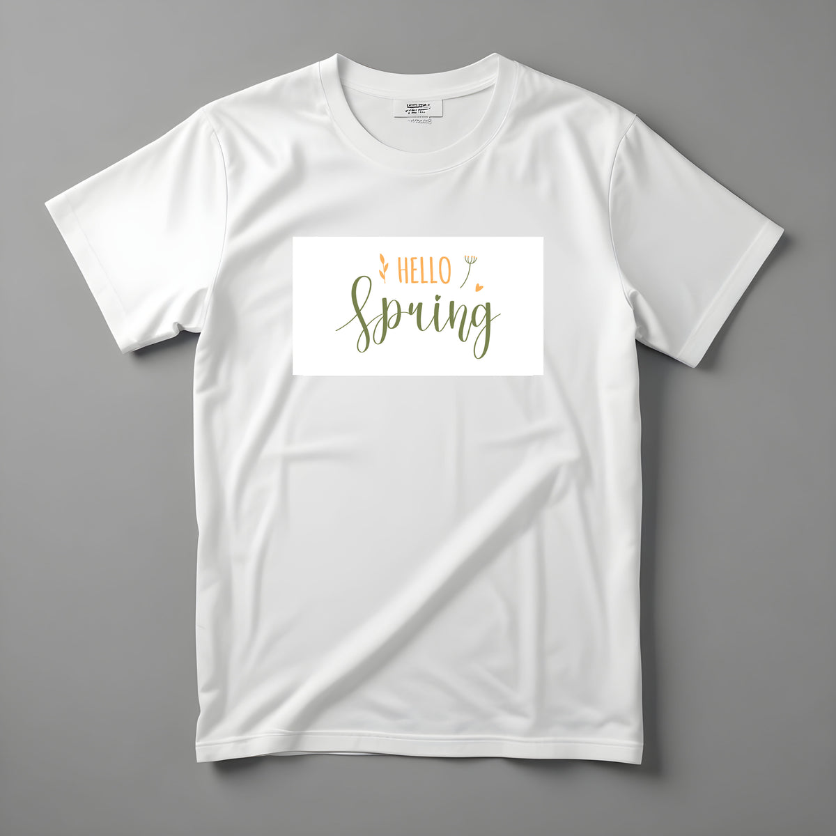 Tricou Kiskedves Hello Spring cu textul scris de mână, verde și auriu, HELLO spring și frunzulițe mici, fotografiat întins.