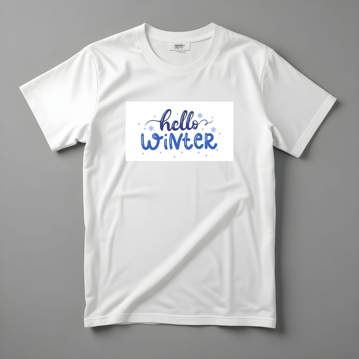 Tricou Kiskedves Hello Winter cu textul albastru scris de mână hello winter și fulgi mici, fotografiat întins.