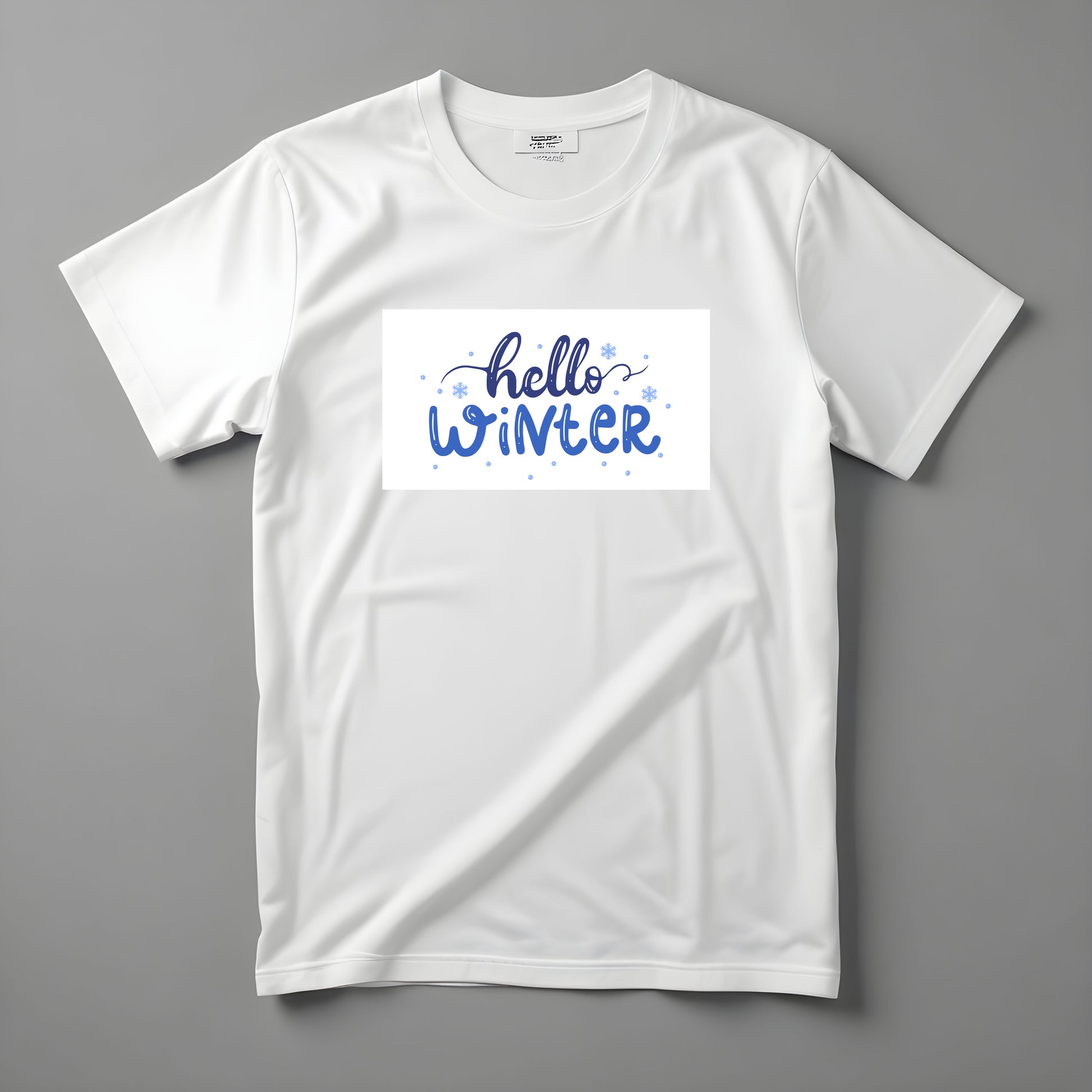 Tricou Kiskedves Hello Winter cu textul albastru scris de mână hello winter și fulgi mici, fotografiat întins.