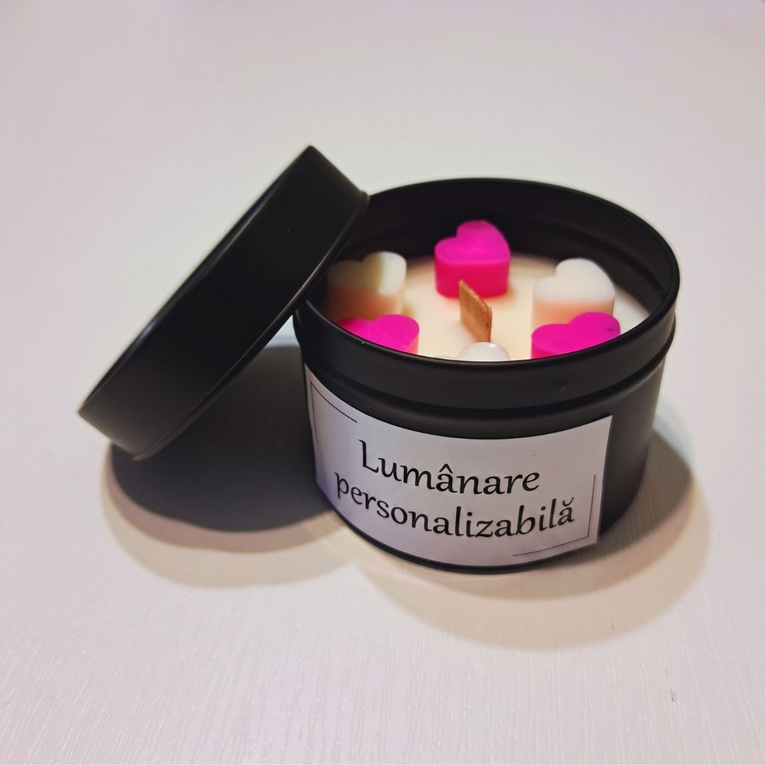 Cutie metalică neagră deschisă cu lumânare din ceară de soia, inimioare de ceară roz și albe și fitil de lemn, cu eticheta „Lumânare personalizabilă”