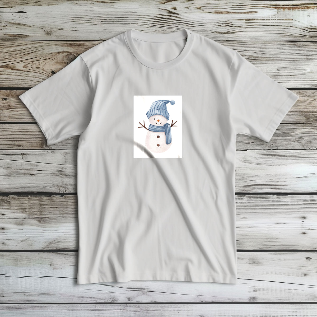 Tricou de iarnă Kiskedves cu un om de zăpadă în acuarelă, cu căciulă albastră în dungi și fular, fotografiat întins.