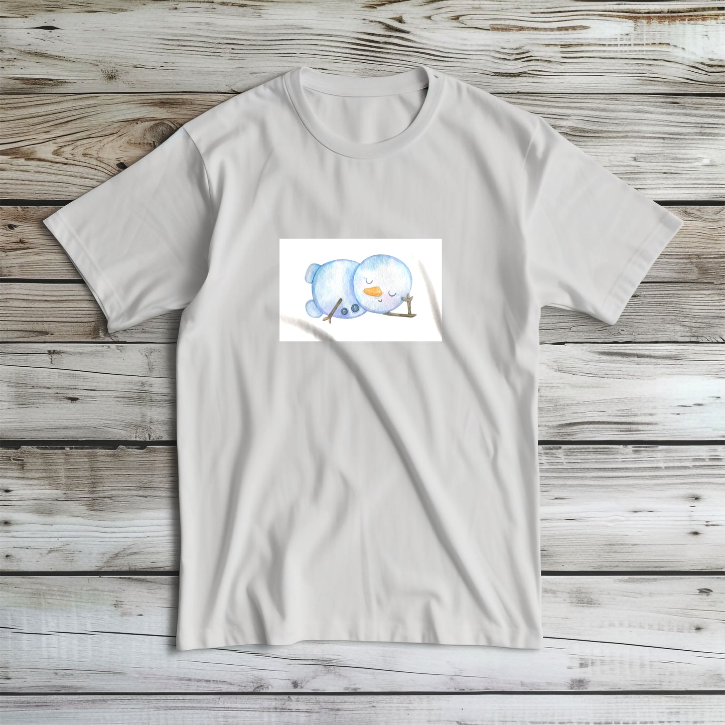 Tricou de iarnă Kiskedves cu un om de zăpadă în acuarelă întins pe o parte, cu ochii închiși și nas de morcov, fotografiat întins.